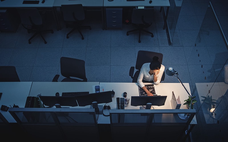 Person sitting at a desk alone at night, working